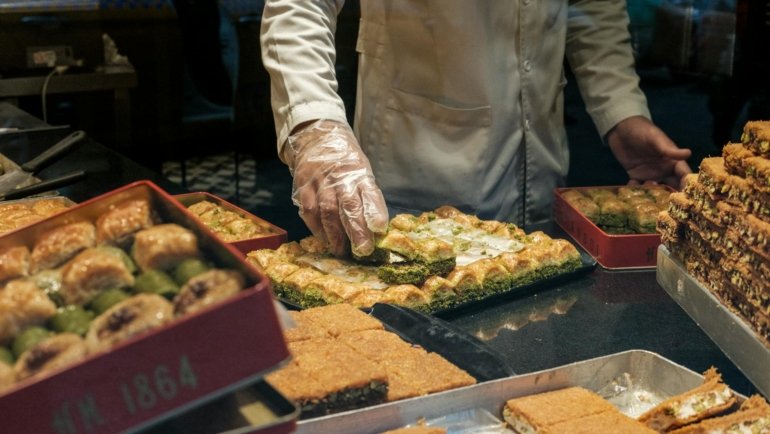 crop seller serving turkish sweets in box