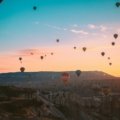 hot air balloons flying over the mountains