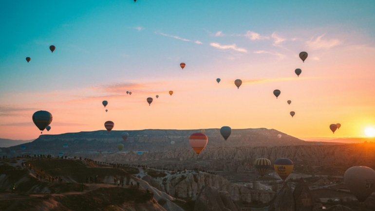 hot air balloons flying over the mountains