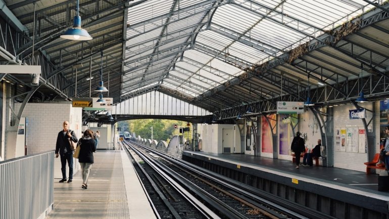 a train station with people walking on the platform