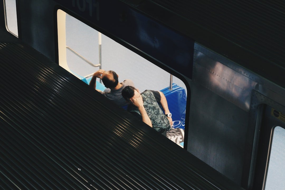 a man sitting on top of a train next to a window