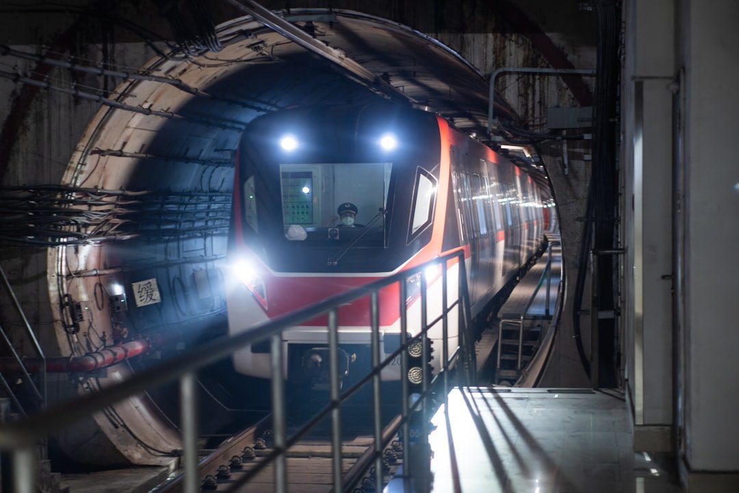 a train traveling through a tunnel next to a loading platform