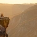 person sitting on rock formation during daytime
