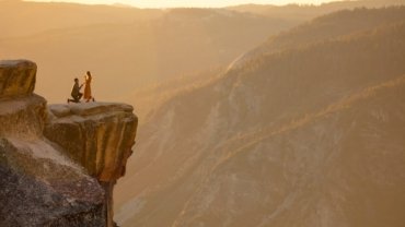 person sitting on rock formation during daytime