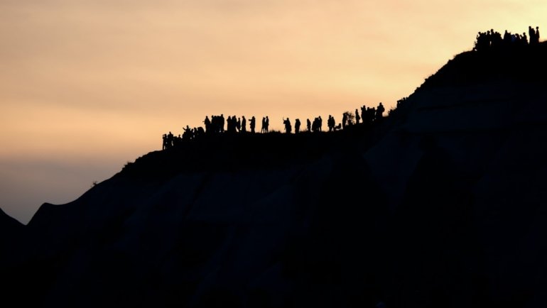 a group of people standing on top of a hill