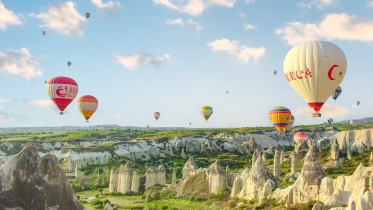 a group of hot air balloons flying over a valley