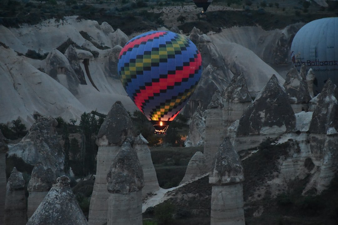Hot air balloon floats above unique rock formations