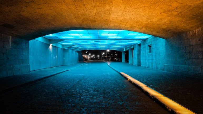 brown and black tunnel with lights turned on during night time