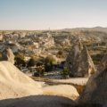 a rocky landscape with a road with Cappadocia in the background