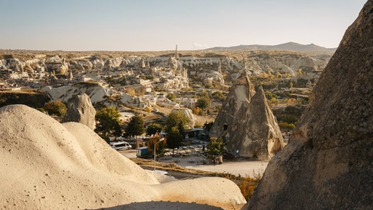 a rocky landscape with a road with Cappadocia in the background