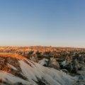 a snowy landscape with a rocky hill