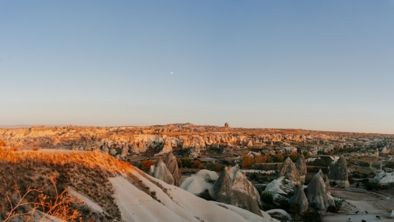 a snowy landscape with a rocky hill