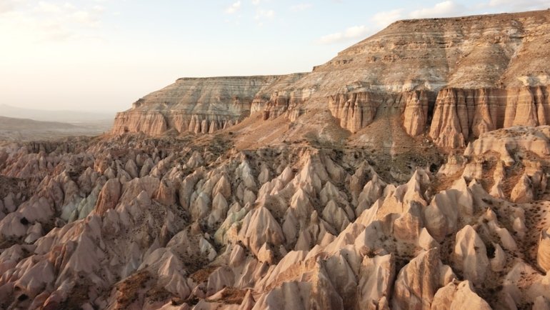 brown rocky mountain under white clouds during daytime