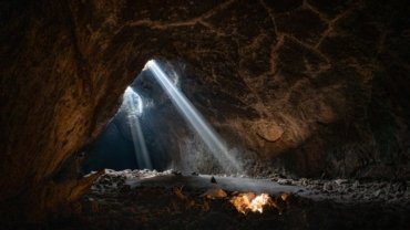a light shines through the opening of a cave