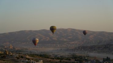 a group of hot air balloons flying over a city
