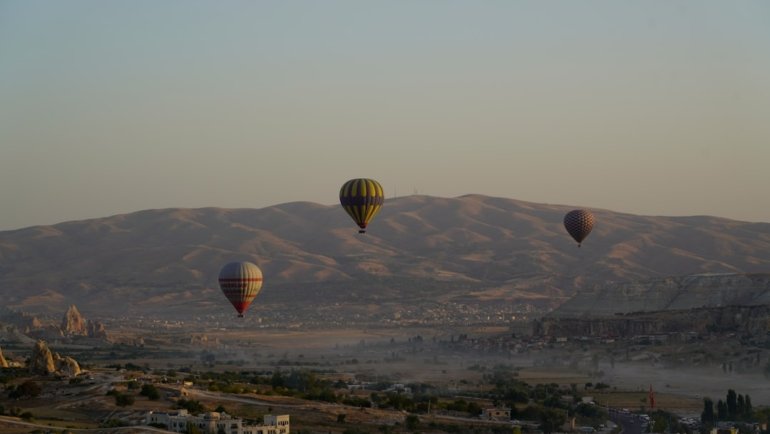 a group of hot air balloons flying over a city