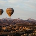 hot air balloon flying over the mountains during daytime