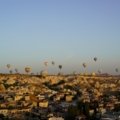 a group of hot air balloons flying over a city
